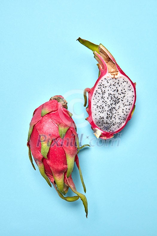 Colorful fruits pattern with Pitahaya tropic fruits, two halfs of fruit on a pastel blue background, copy space. Top view. Colorful fruits pattern with Pitahaya tropic fruits, two halfs of fruit on a pastel blue background, copy space. Top view.