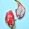 Colorful fruits pattern with Pitahaya tropic fruits, two halfs of fruit on a pastel blue background, copy space. Top view.