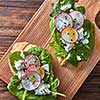 Bruschetta with radishes, spinach and curd cheese with flax seeds on a wooden background, place for text. Healthy natural snack. Flat lay