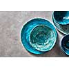 Decorative pottery - bowls, plates covered with glazed on a gray background, place for text. Top view of traditional handcrafted.