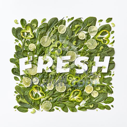 Healthy variety of green vegetables cabbage, spinach,flower petals, asparagus pieces pepper on a gray background with a paper inscription fresh on a gray background with copy space. Flat lay Healthy variety of green vegetables cabbage, spinach,flower petals, asparagus pieces pepper on a gray background with a paper inscription fresh on a gray background with copy space. Flat lay