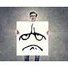 Businessman hold white board with sad face emoticon