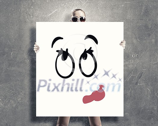 Young woman showing white banner with smile emoticon Young woman showing white banner with smile emoticon