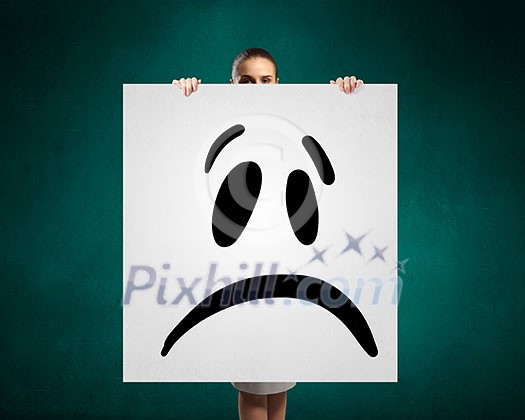 Portrait of a young attractive woman with sad smiley on banner Portrait of a young attractive woman with sad smiley on banner