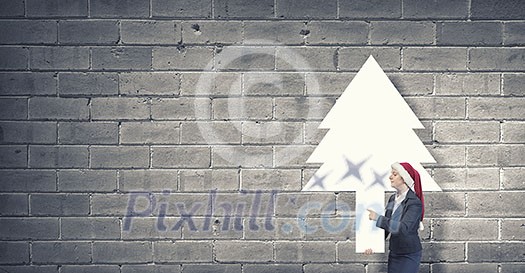 Woman in Santa hat pointing with finger at blank banner. Place for your text Woman in Santa hat pointing with finger at blank banner. Place for your text