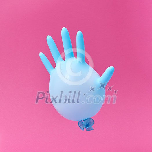 Flying blue rubber surgical glove as a balloon on a hot pink background with copy space. Minimalism concept. Flying blue rubber surgical glove as a balloon on a hot pink background with copy space. Minimalism concept.