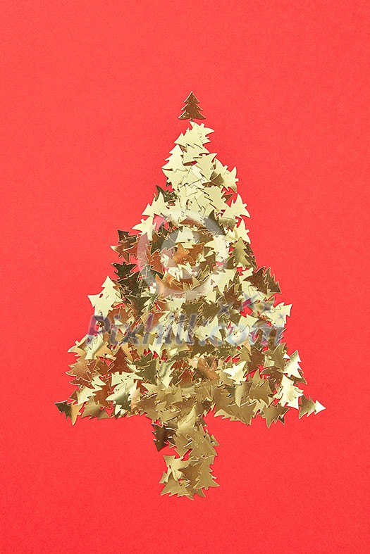 New Year creative decorative tree handmade frome shiny small spruces on a red background with place for text. Greeting holiday card. New Year creative decorative tree handmade frome shiny small spruces on a red background with place for text. Greeting holiday card.