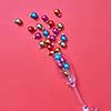 Christmas decoration balls in a glass as a champagne alcohol drink on a calypso coral background with plase for text. Greeting holiday card.