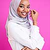 portrait of young modern muslim afro beauty wearing traditional islamic clothes on plastic pink background