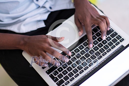 Close up shot of African student using laptop computer to study and make business connections Close up shot of African student using laptop computer to study and make business connections