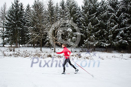 Cross-country skiing: young woman cross-country skiing on a winter day (motion blurred image) Cross-country skiing: young woman cross-country skiing on a winter day (motion blurred image)
