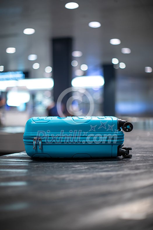 Arrived luggage going around on a conveyor belt waiting to be claimed at the baggage claim zone at a modern international airport Arrived luggage going around on a conveyor belt waiting to be claimed at the baggage claim zone at a modern international airport