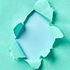 Creative handmade frame from torn turquoise paper on a pastel blue background with copy space. Can be used for your creativity.