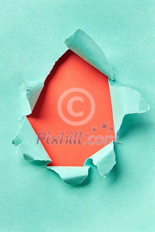 Handmade decoration frame from torn turquoise paper on a coral background with copy space. Can be used for your creativity. Handmade decoration frame from torn turquoise paper on a coral background with copy space. Can be used for your creativity.