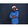 Indian man wearing traditional Santa Claus hat on chalkboard  background studio dark-skinned Christmas santa new year party