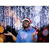 Indian man wearing traditional Santa Claus hat on chalkboard  background studio dark-skinned Christmas santa new year party