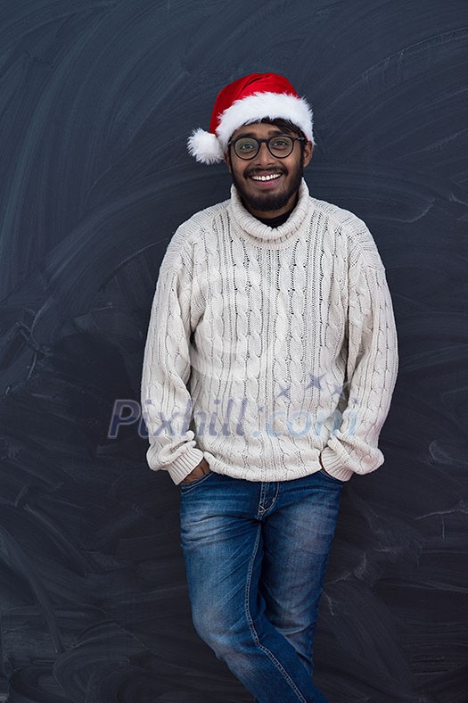 Indian man wearing traditional Santa Claus hat and white sweater on chalkboard background studio dark-skinned Christmas santa new year party Indian man wearing traditional Santa Claus hat and white sweater on chalkboard background studio dark-skinned Christmas santa new year party