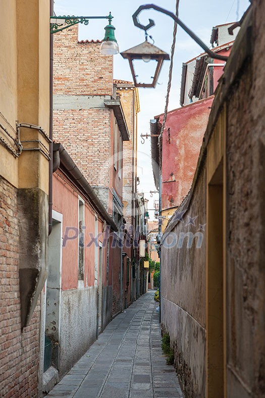 Venetian buildings represented onnarrow street in Italy. Narrow road in Venice, Italy. Venetian buildings represented onnarrow street in Italy. Narrow road in Venice, Italy.