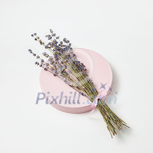 Natural branch of lavender flowers on a round board on a light grey background with copy space. Creeting card. Natural branch of lavender flowers on a round board on a light grey background with copy space. Creeting card.