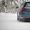 Car on a snowy winter road amid forests - using its four wheel drive capacities to get through the snow