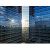 Aerial shot of modern office building windows, reflection of cityscape on a sunny day.