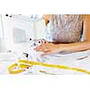 Close up of woman dressmaker hands working with sewing machine