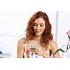 Portrait of young pretty woman sitting at cafe and using mobile phone