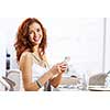 Portrait of young pretty woman sitting at cafe and using mobile phone