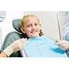Cute smiling girl in at dentist sitting in armchair
