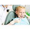 Cute smiling girl in at dentist sitting in armchair