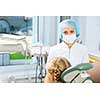 Cute smiling girl in at dentist sitting in armchair