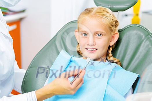 Cute smiling girl in at dentist sitting in armchair Cute smiling girl in at dentist sitting in armchair