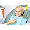 Cute smiling girl in at dentist sitting in armchair