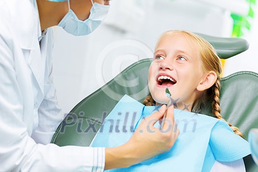 Cute smiling girl in at dentist sitting in armchair Cute smiling girl in at dentist sitting in armchair