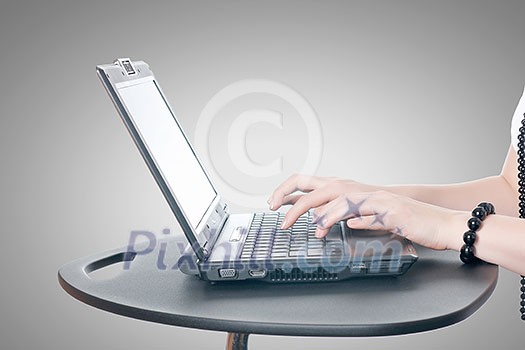 Close up of woman's hands using laptop and splashes out of monitor Close up of woman's hands using laptop and splashes out of monitor