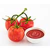 Freshly prepared ketchup with ripe red tomatoes on a white background