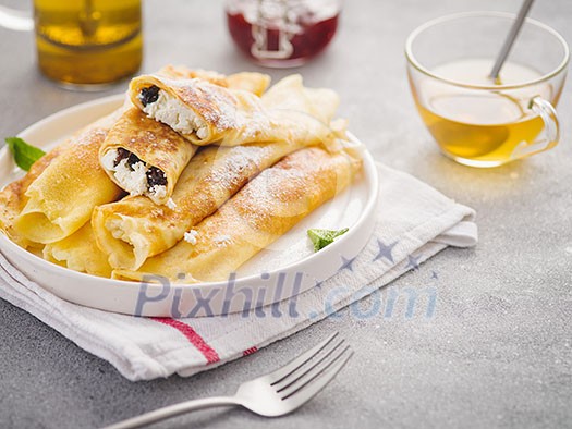 Breakfast of pancakes with cottage cheese and raisins. Tasty dessert. Crepes. Breakfast of pancakes with cottage cheese and raisins. Tasty dessert. Crepes.