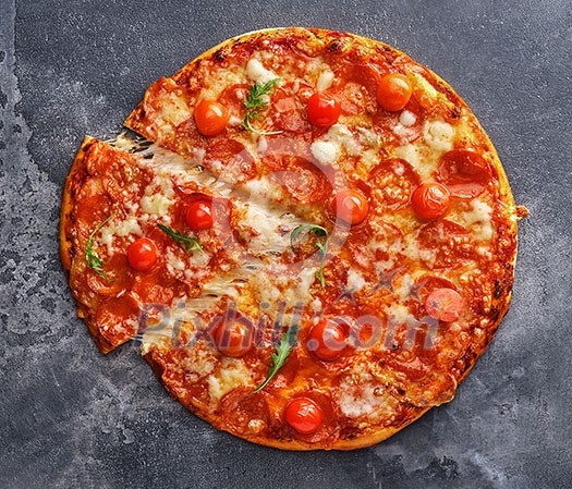 Slice of pepperoni pizza with cherry tomatoes. Sliced tasty pepperoni pizza on the grey stone background. Top view. Slice of pepperoni pizza with cherry tomatoes. Sliced tasty pepperoni pizza on the grey stone background. Top view.