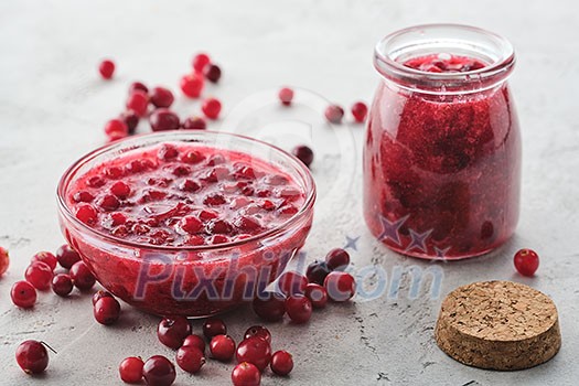 Cranberry jam in a glass bowl on a gray background Cranberry jam in a glass bowl on a gray background