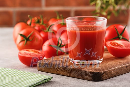 Tasty Tomato juice in a glass with ripe red tomatoes Tasty Tomato juice in a glass with ripe red tomatoes