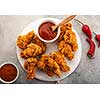 Spicy chicken wings breaded with spices and ketchup on the table, top view