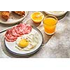 Continental breakfast. Fried eggs and sausage with croissants and orange juice