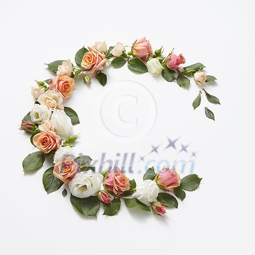 Decoration in the form of corner wreath from beautiful roses flowers with green leaves on a light grey background, copy space. Congratulation card for birthday. Decoration in the form of corner wreath from beautiful roses flowers with green leaves on a light grey background, copy space. Congratulation card for birthday.