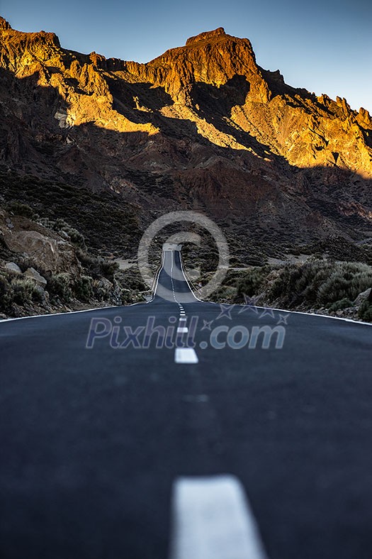 Long road in a mountain valley with a car on it - Teide National Park, Tenerife, Canary islands Long road in a mountain valley with a car on it - Teide National Park, Tenerife, Canary islands