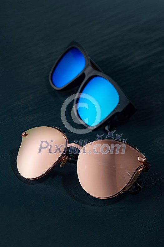 Fashionable sun glasses on a dark blue background with copy space. Modern accessory for protection eyes. Fashionable sun glasses on a dark blue background with copy space. Modern accessory for protection eyes.