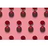 Rows with glasses of red wine alcohol drink on a pink background with hard shadows. Top view. Alcohol drink pattern.
