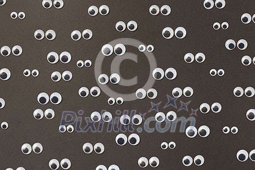 Sad googly eyes from clear, hard-plastic shell with a small black plastic disk different sizes on a black background. Top view. Sad googly eyes from clear, hard-plastic shell with a small black plastic disk different sizes on a black background. Top view.
