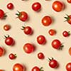 Freshly picked red ripe organic cherry tomatoes on a beige background. Top view. Vegetable vegan pattern.