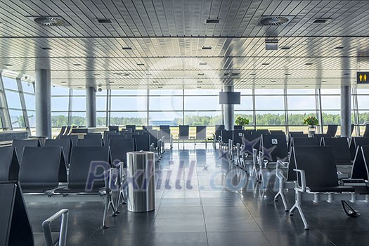 Empty departure hall at airport with comfortable chairs for waiting. Travel and transportation concept. Empty departure hall at airport with comfortable chairs for waiting. Travel and transportation concept.