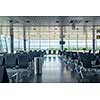 Empty departure hall at airport with comfortable chairs for waiting. Travel and transportation concept.